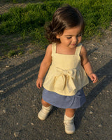 Conjunto blusa amarilla de tiras con moño y falda short azul para bebé niña