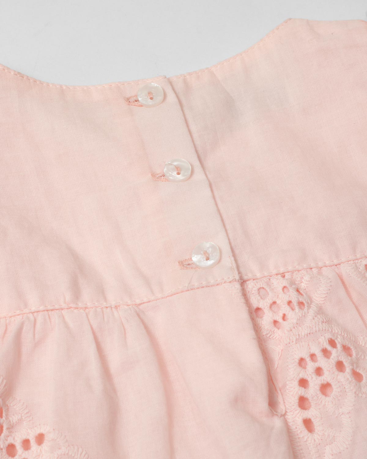 Vestido body rosa en tela hoja rota con detalle de moño para bebé niña