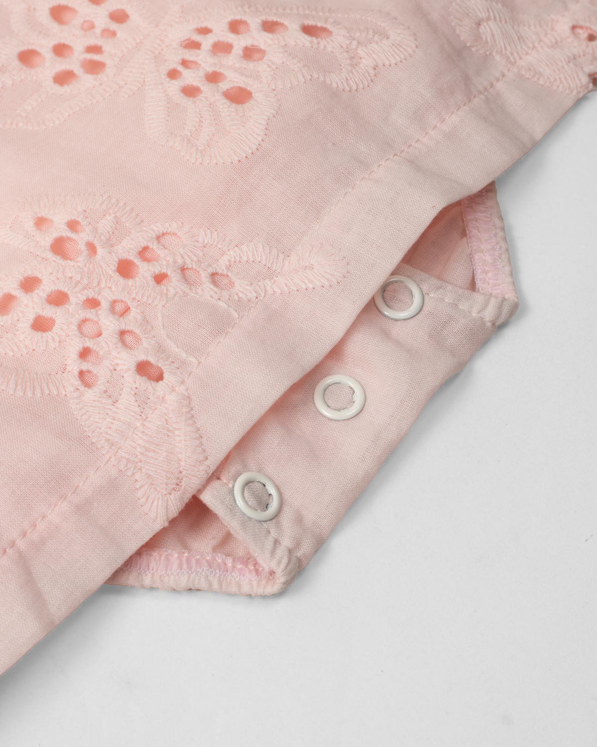 Vestido body rosa en tela hoja rota con detalle de moño para bebé niña