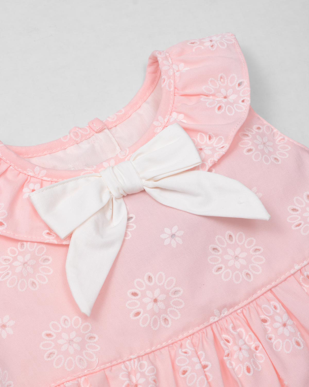 Vestido body rosa en tela hoja rota con estampado de flores y moño blanco para bebé niña
