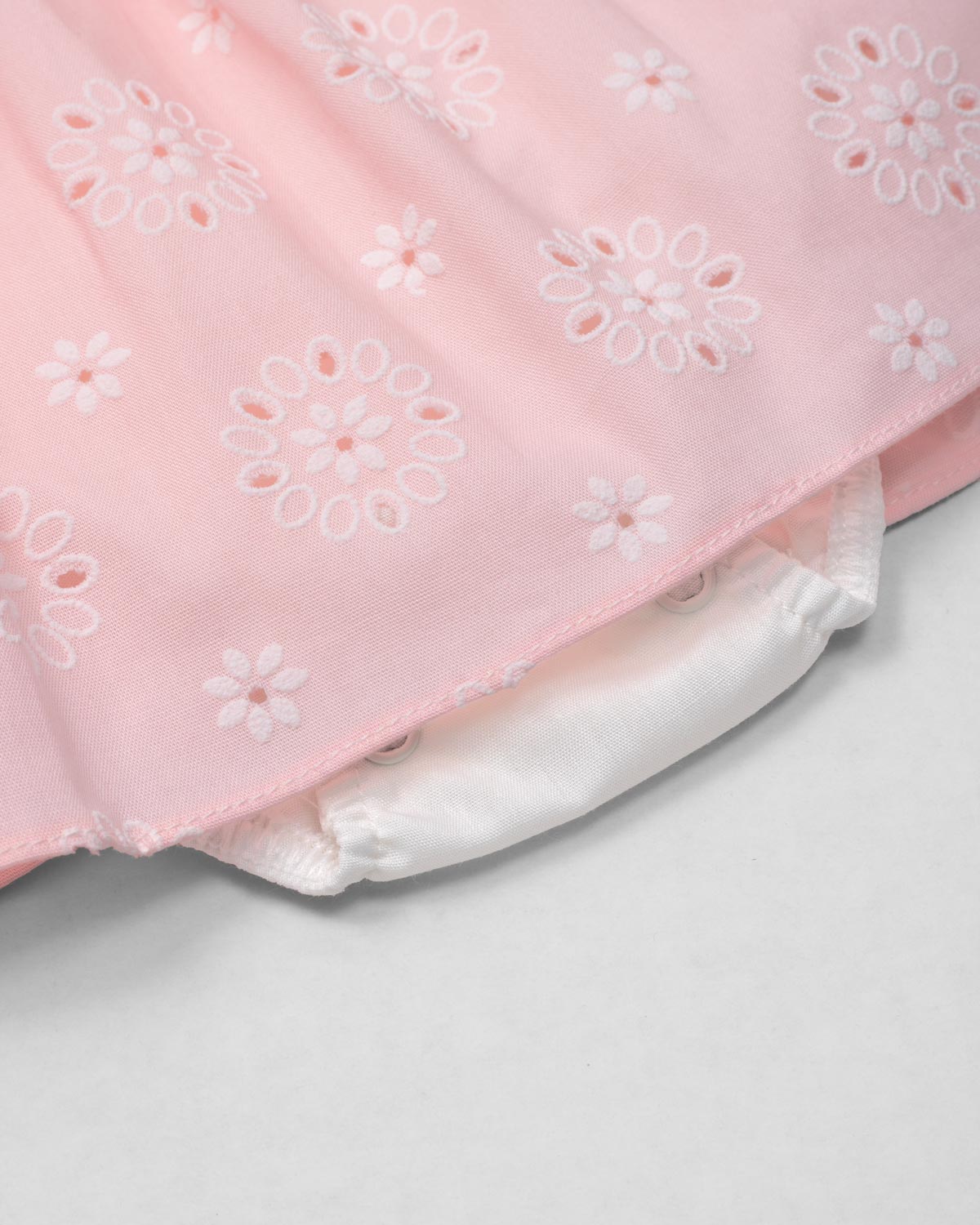 Vestido body rosa en tela hoja rota con estampado de flores y moño blanco para bebé niña
