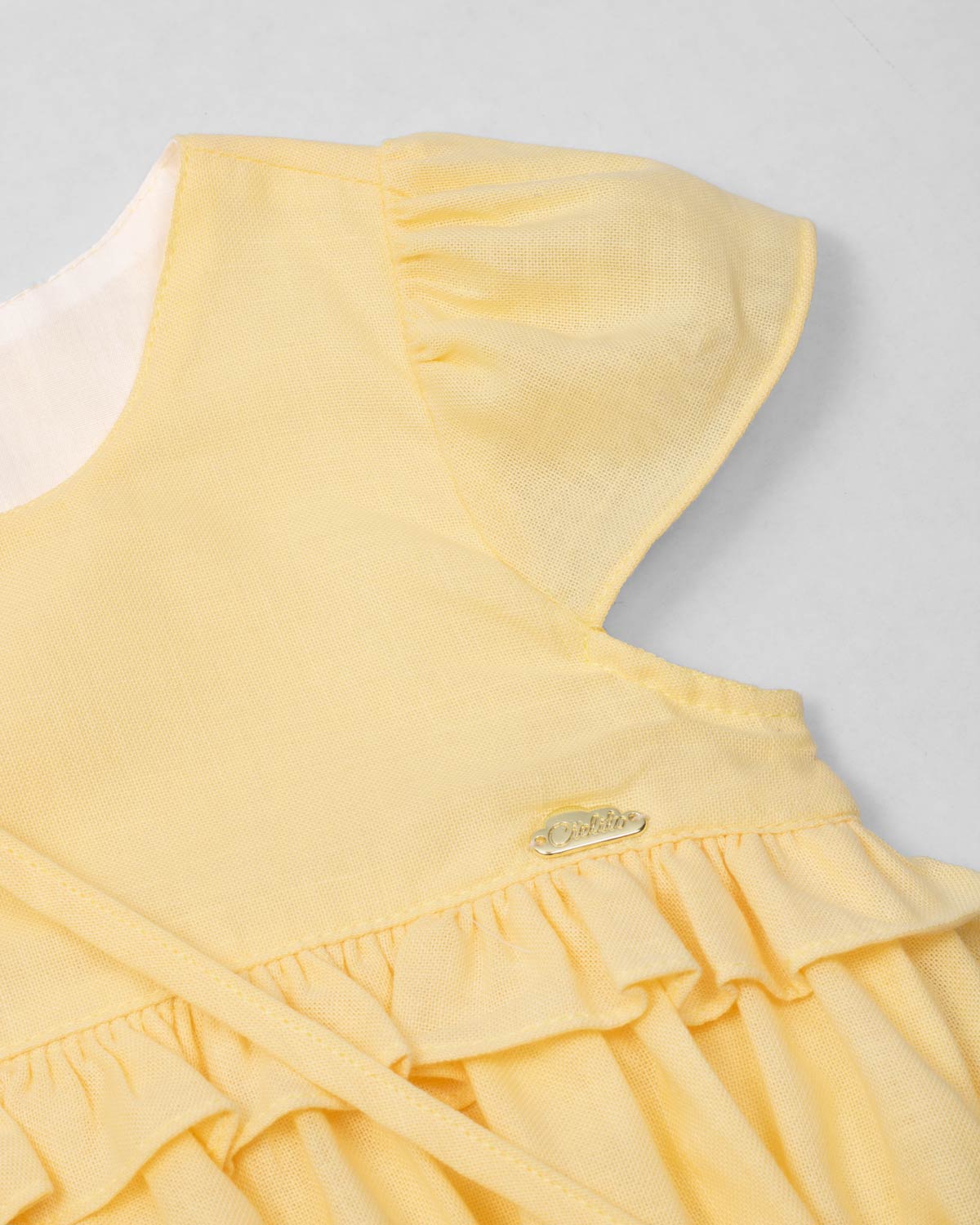 Vestido body en lino amarillo con osito tipo bolso para bebé niña