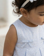 Vestido body en tela hoja rota azul con flores y moñitos para bebé niña