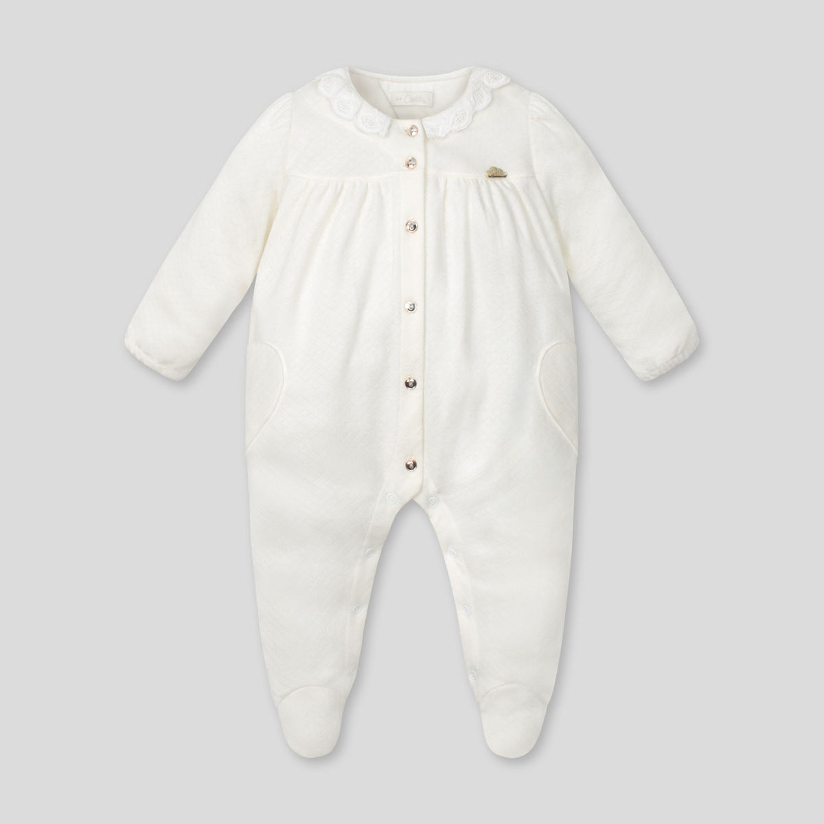 Pijamas enteriza blanca crema con botones y corazones en los costados para bebé niña