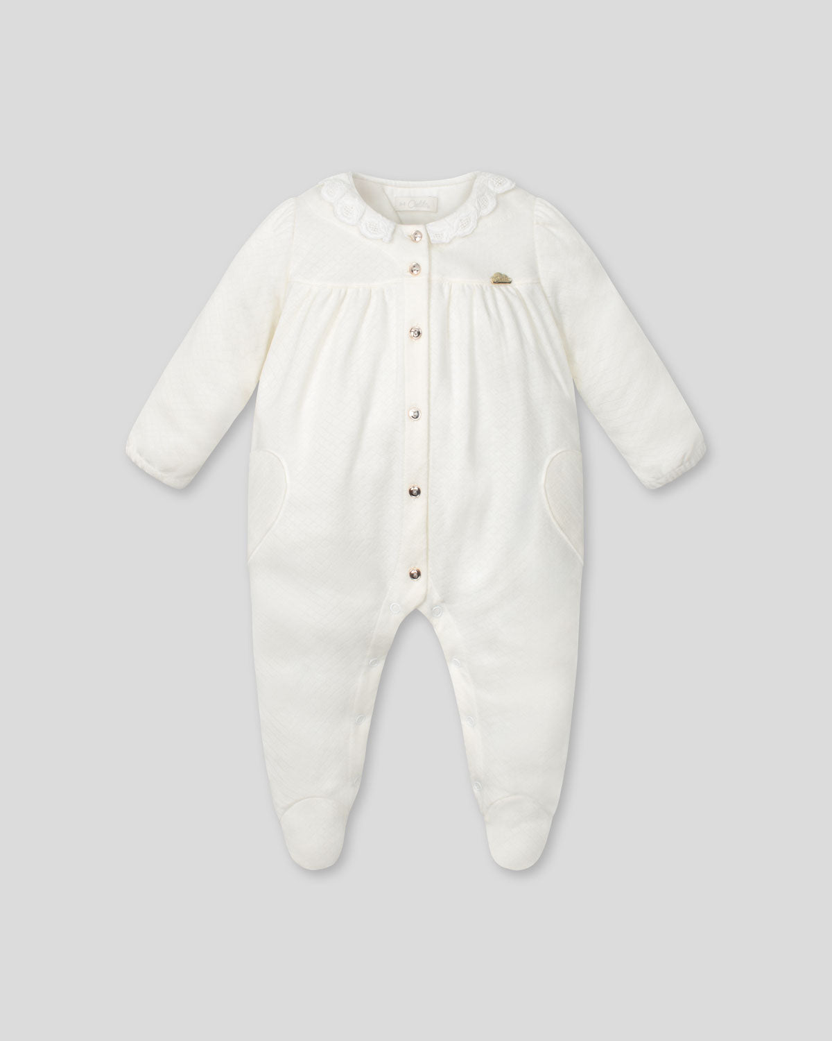 Pijamas enteriza blanca crema con botones y corazones en los costados para bebé niña