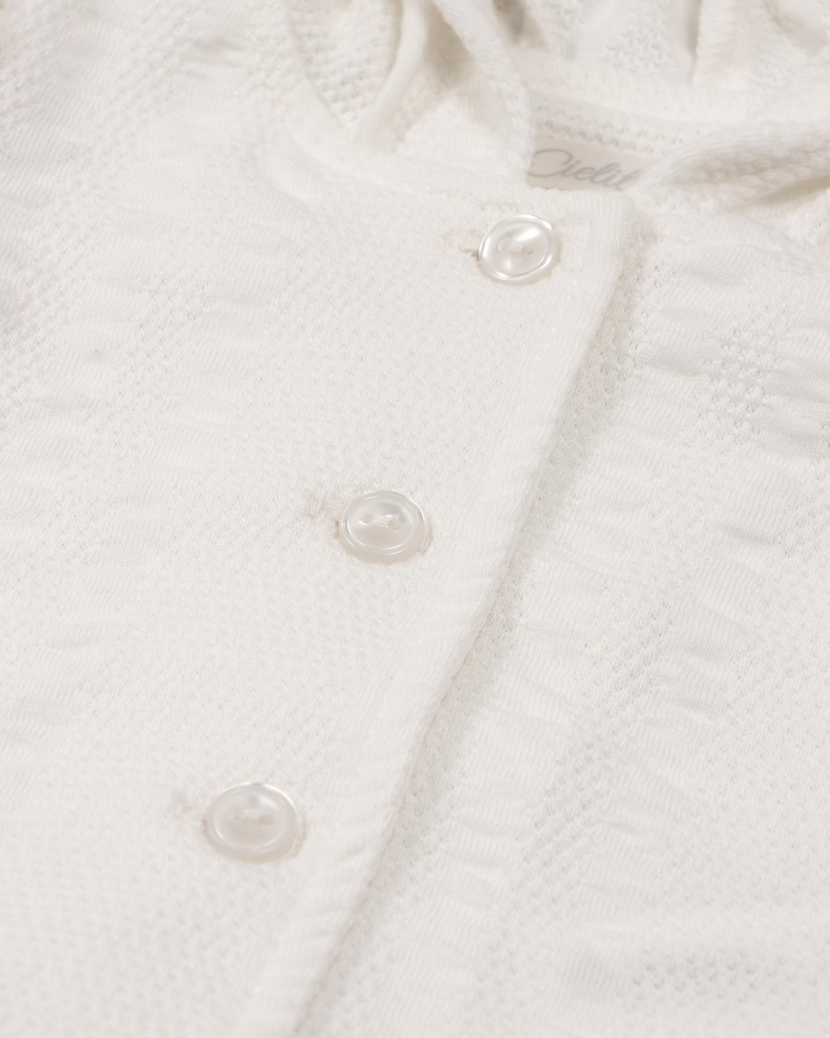Pijama blanca de dos piezas con gorrito para recién nacida