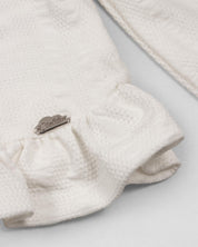 Pijama blanca de dos piezas con gorrito para recién nacida