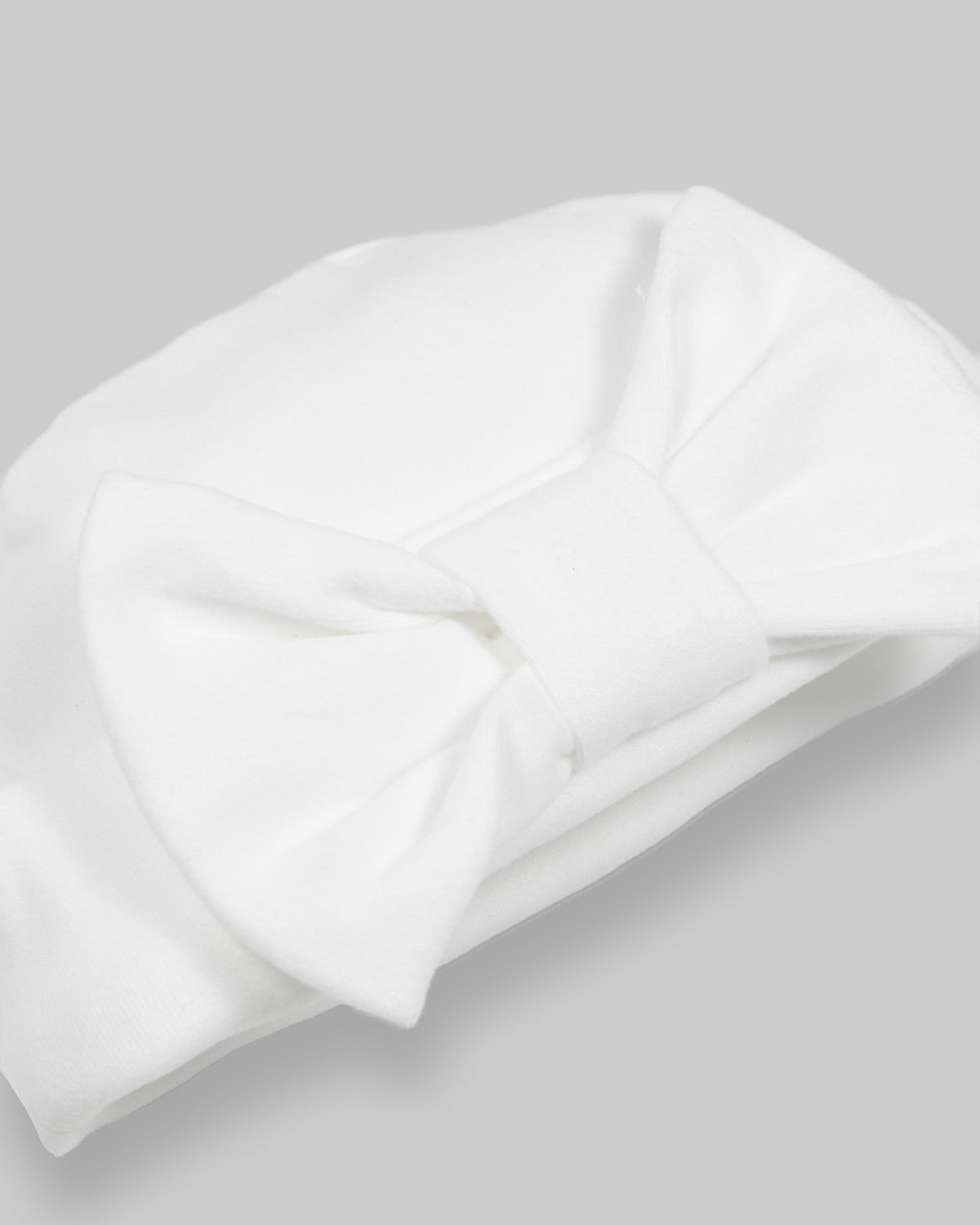 Ajuar blanco de dos piezas, gorrito y cobija para recién nacida.