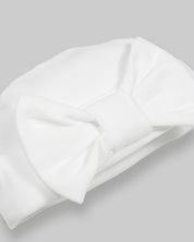 Ajuar blanco de dos piezas, gorrito y cobija para recién nacida.