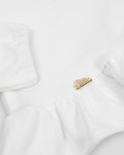 Ajuar blanco de dos piezas, gorrito y cobija para recién nacida.