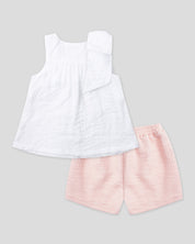 Blusa blanca en tencel con botonadura, moño en hombro y short rosa para niña