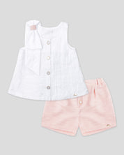 Blusa blanca en tencel con botonadura, moño en hombro y short rosa para niña