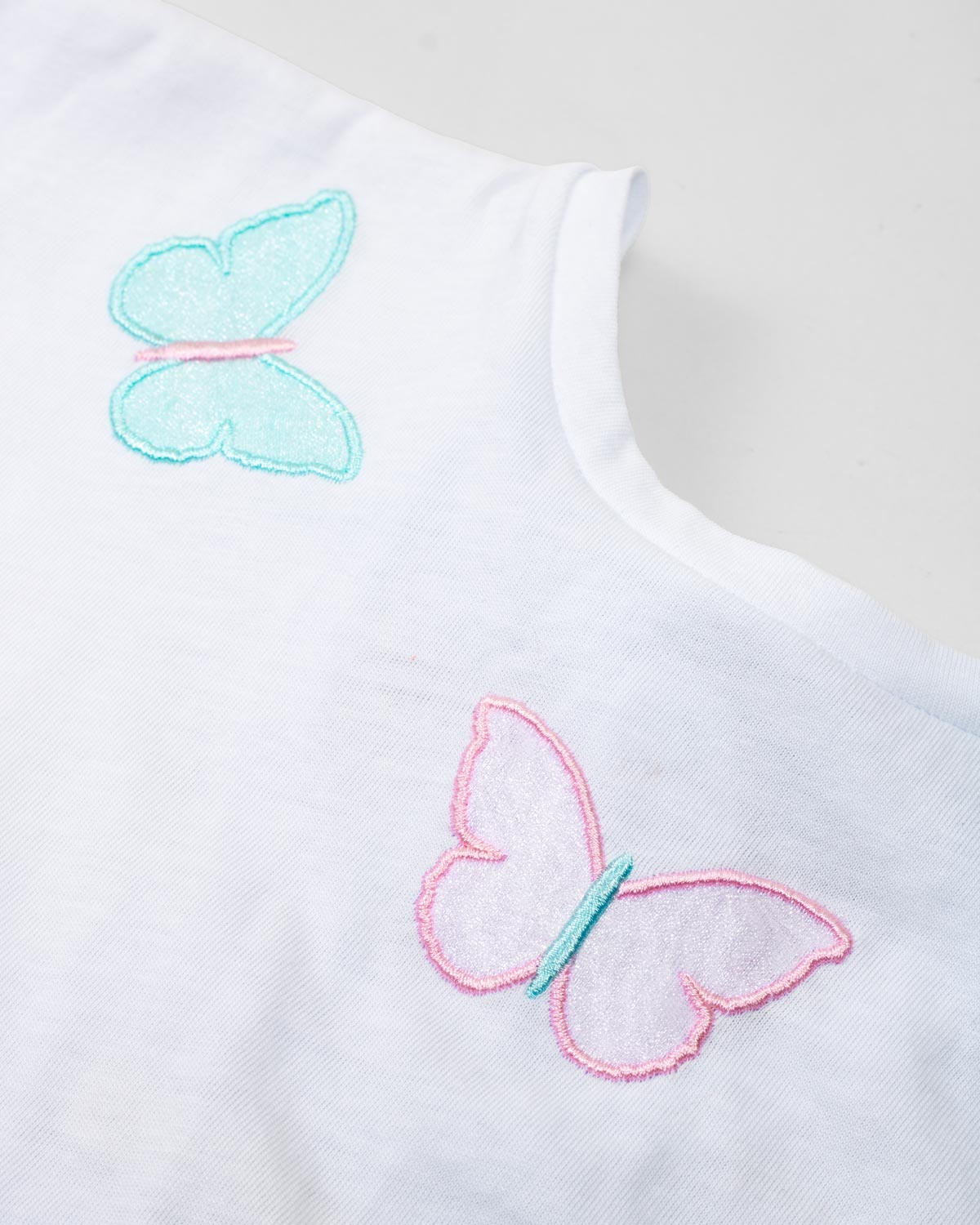 Conjunto camiseta blanca con bordado de mariposas y short rosado para niña