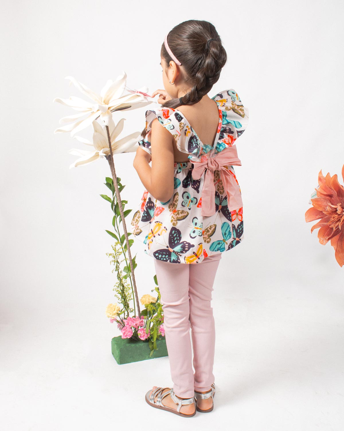 Conjunto blusa estampada de mariposas con bolero en manga, detalle de moño y leggins rosado para niña