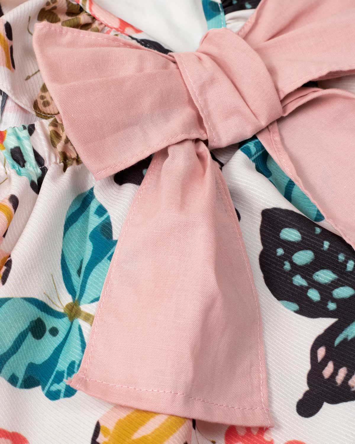 Conjunto blusa estampada de mariposas con bolero en manga, detalle de moño y leggins rosado para niña