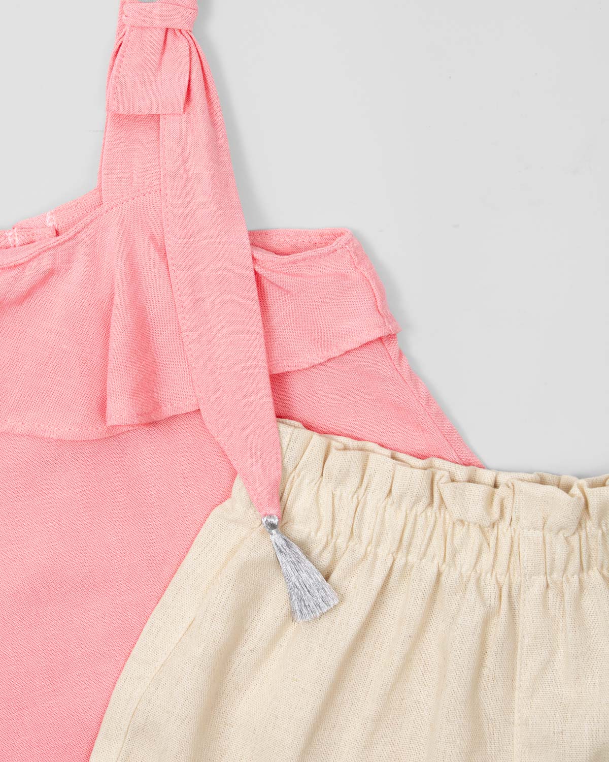 Conjunto blusa rosa en lino con bolero, moños en tiras con detalle de borlas y short beige para niña