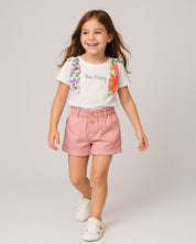 Conjunto blusa blanca con moños estampados en hombro y short rosa con bolsillos para niña
