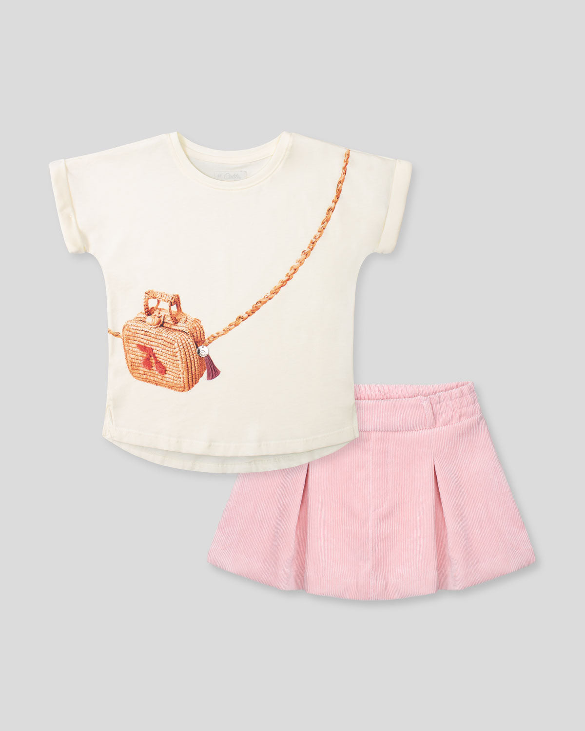 Conjunto blusa vainilla con estampado de bolso y falda rosa para niña