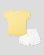 Conjunto camiseta amarilla con estampado, apliques y short blanco para niña