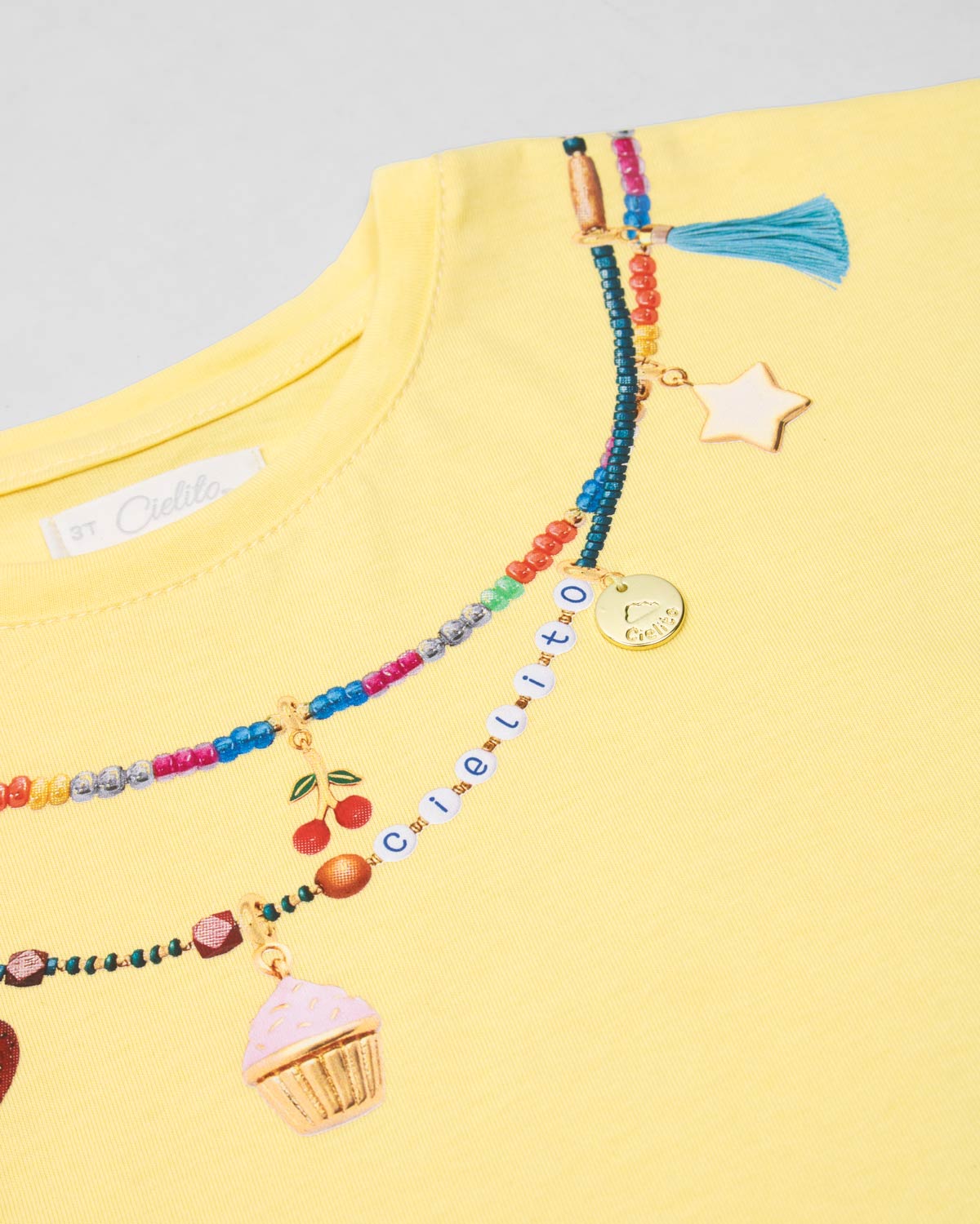 Conjunto camiseta amarilla con estampado, apliques y short blanco para niña