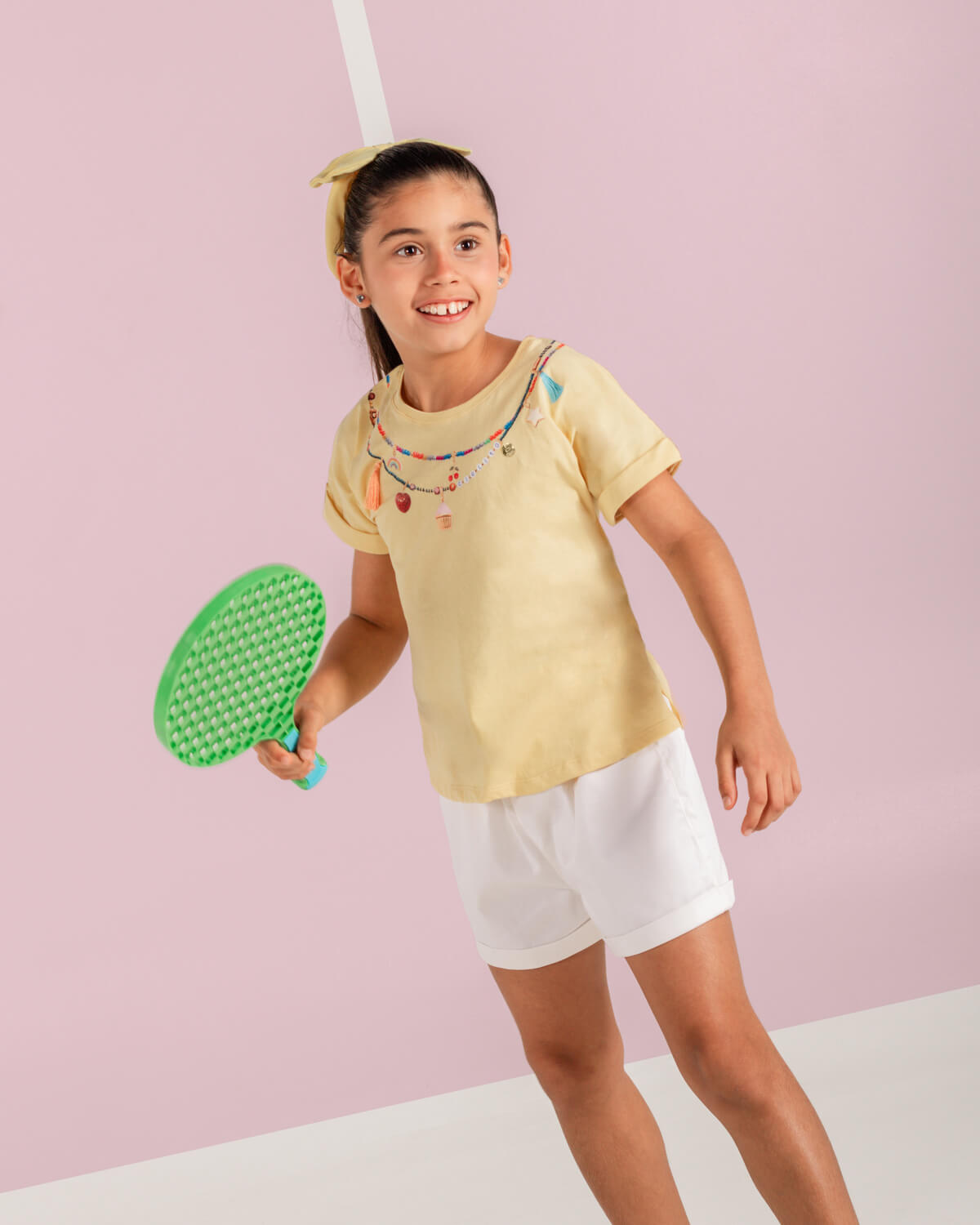 Conjunto camiseta amarilla con estampado, apliques y short blanco para niña