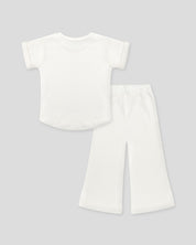 Conjunto blusa y pantalón blancos en tejido texturizado para niña