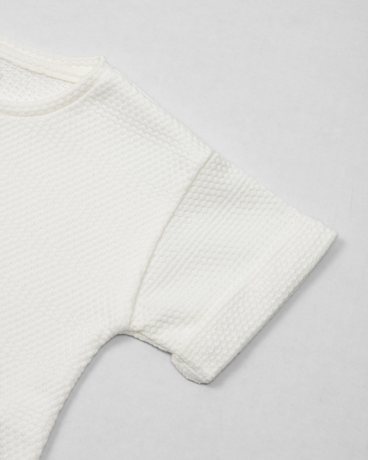 Conjunto blusa y pantalón blancos en tejido texturizado para niña