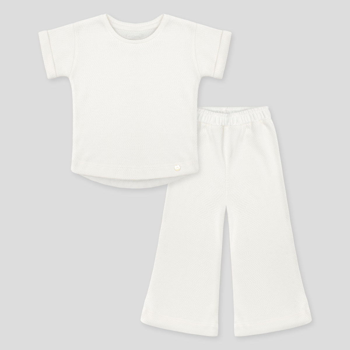 Conjunto blusa y pantalón blancos en tejido texturizado para niña