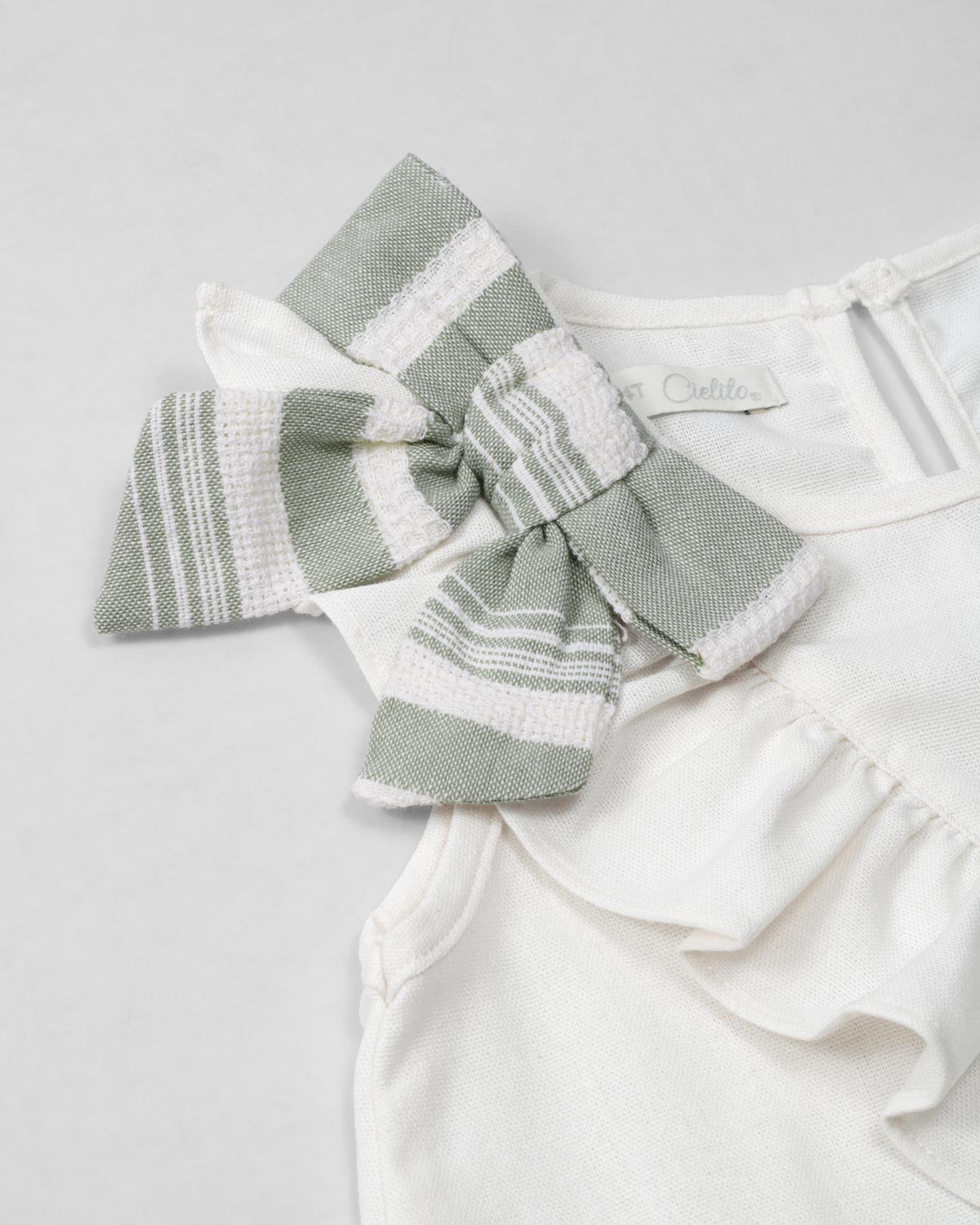 Conjunto blusa blanca de bolero cruzado con moño y pantalón verde en lino para niña
