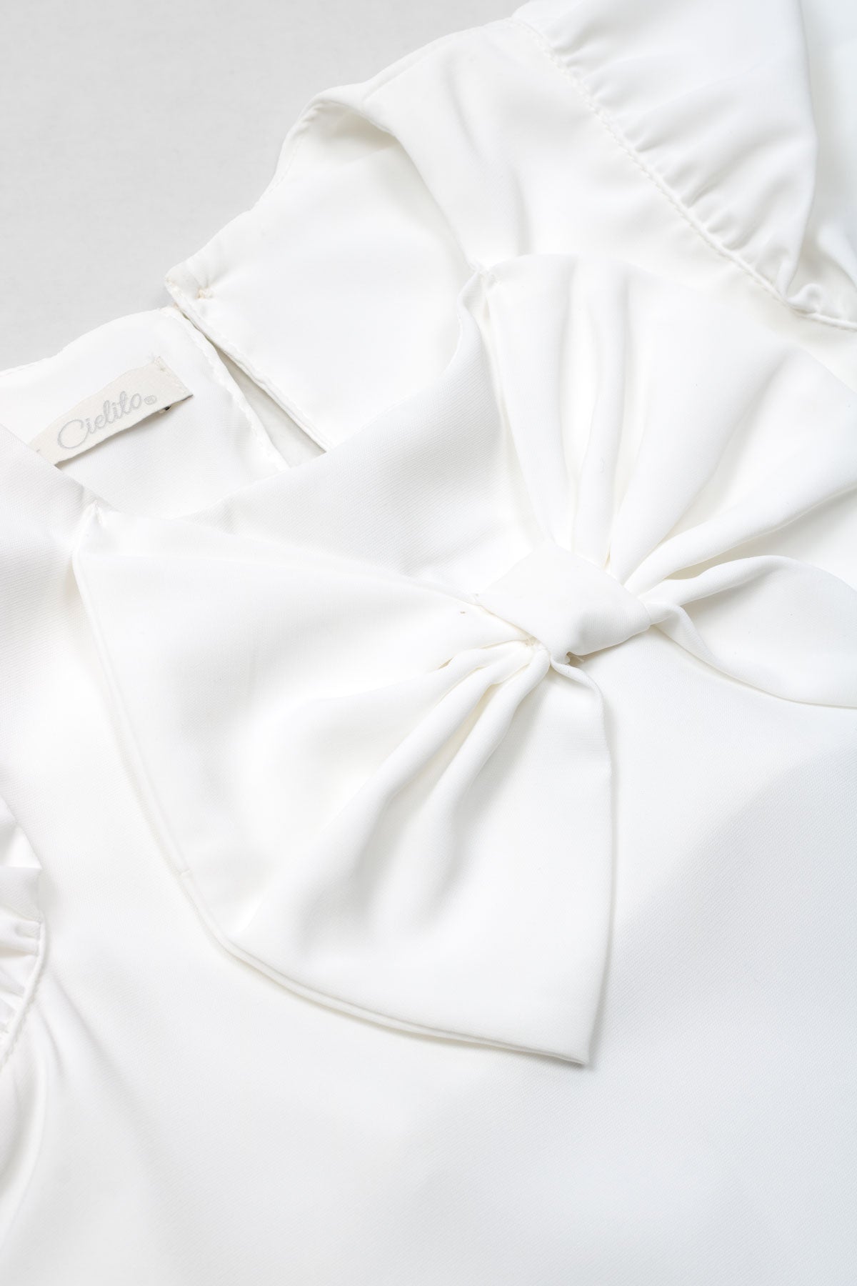 Conjunto blusa blanca en satín con moño y short de puntos dorados para niña