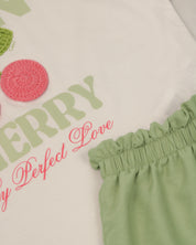 Conjunto camiseta blanca con estampado "Mon Cherry" y short verde para niña