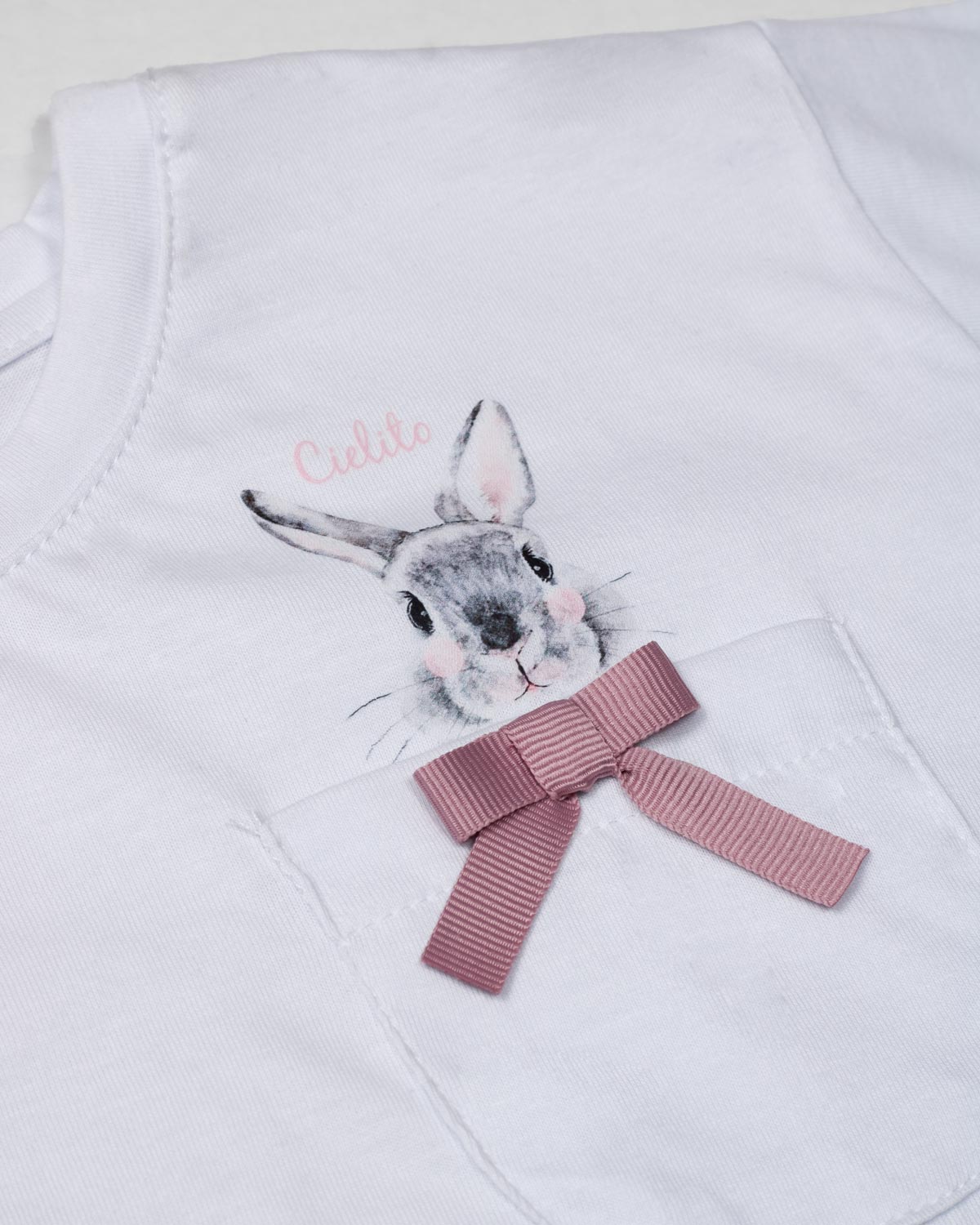 Conjunto blusa blanca con bolsillo, estampado en espalda de conejo y short rosa para niña