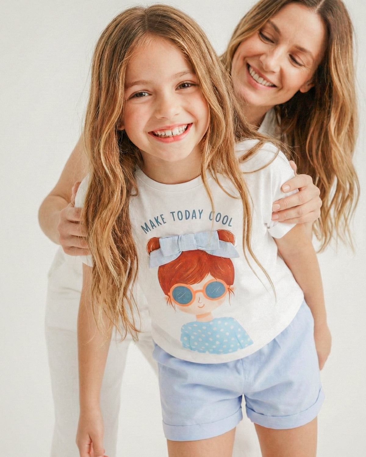 Conjunto blusa blanca con estampado moño  y short azul para niña