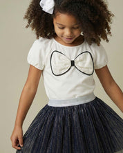 Conjunto blusa blanca con moño y falda negra plisada brillante para niña