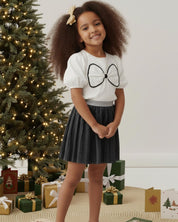 Conjunto blusa blanca con moño y falda negra plisada brillante para niña