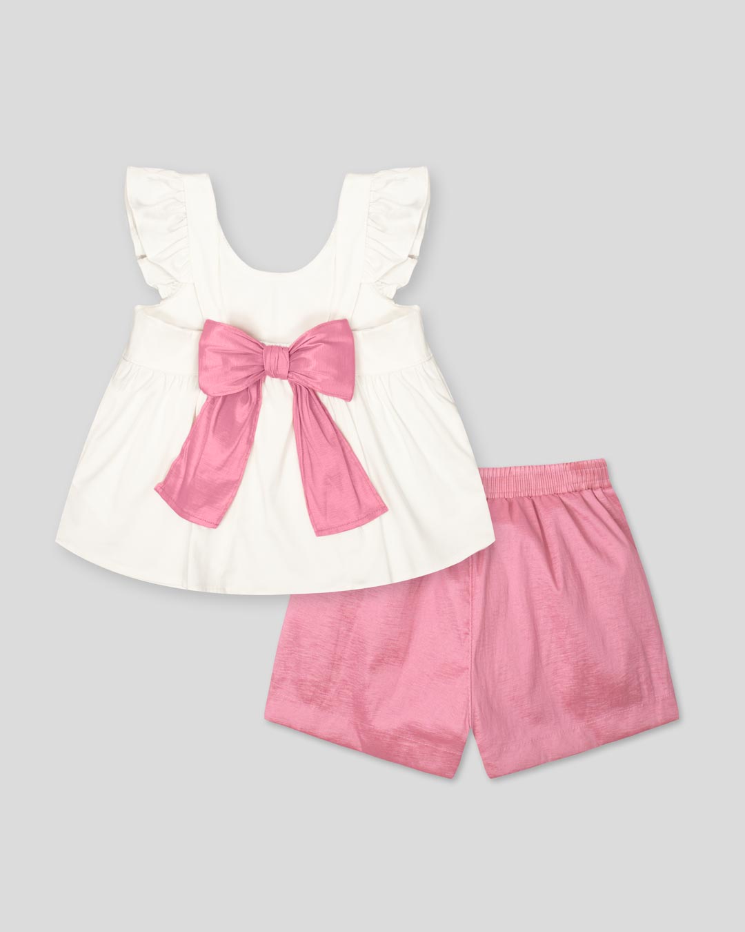 Conjunto blusa blanca con moño en espalda y short rosa brillante para niña