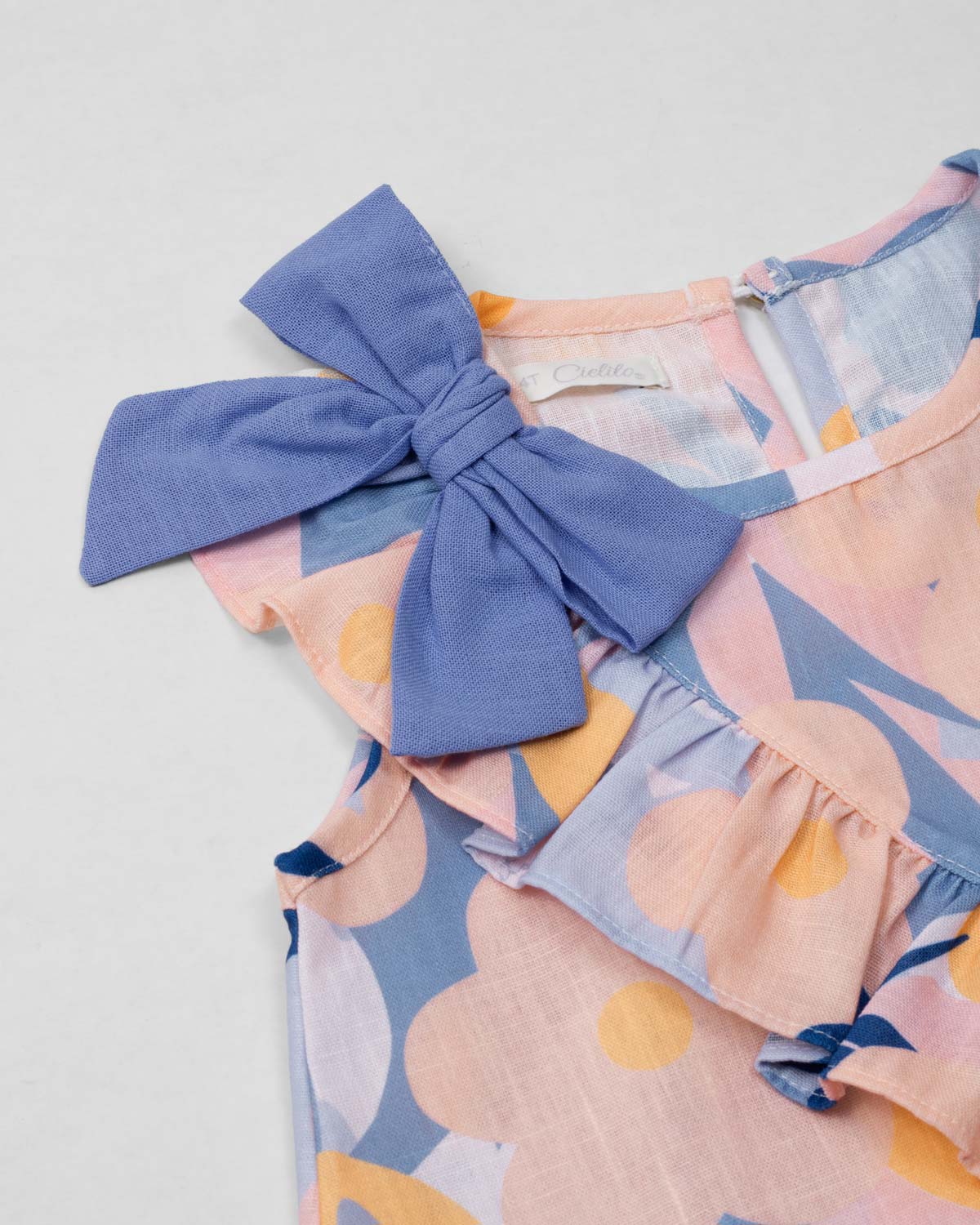 Conjunto blusa estampada con moño en hombro, boleto cruzado y short azul para niña