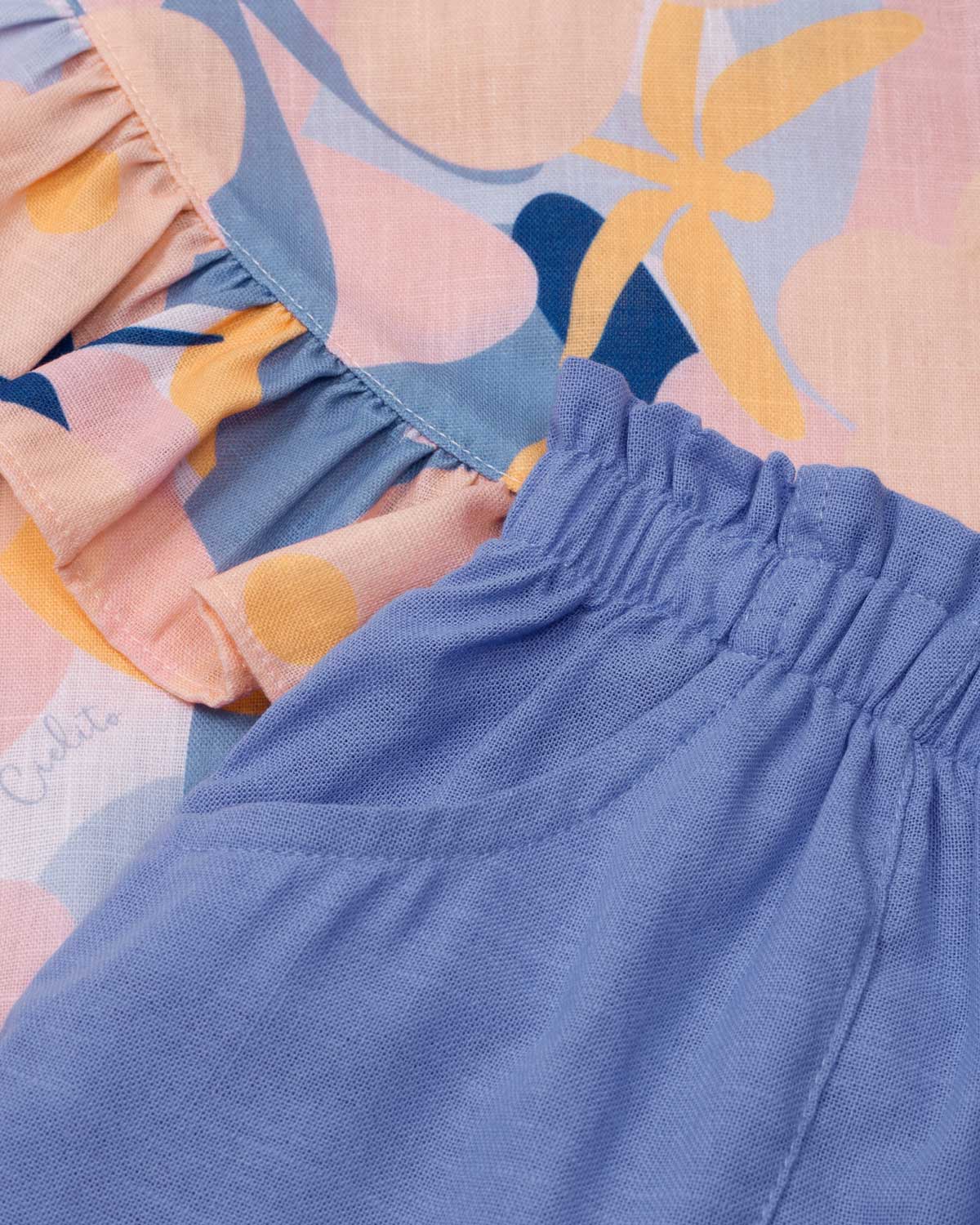 Conjunto blusa estampada con moño en hombro, boleto cruzado y short azul para niña