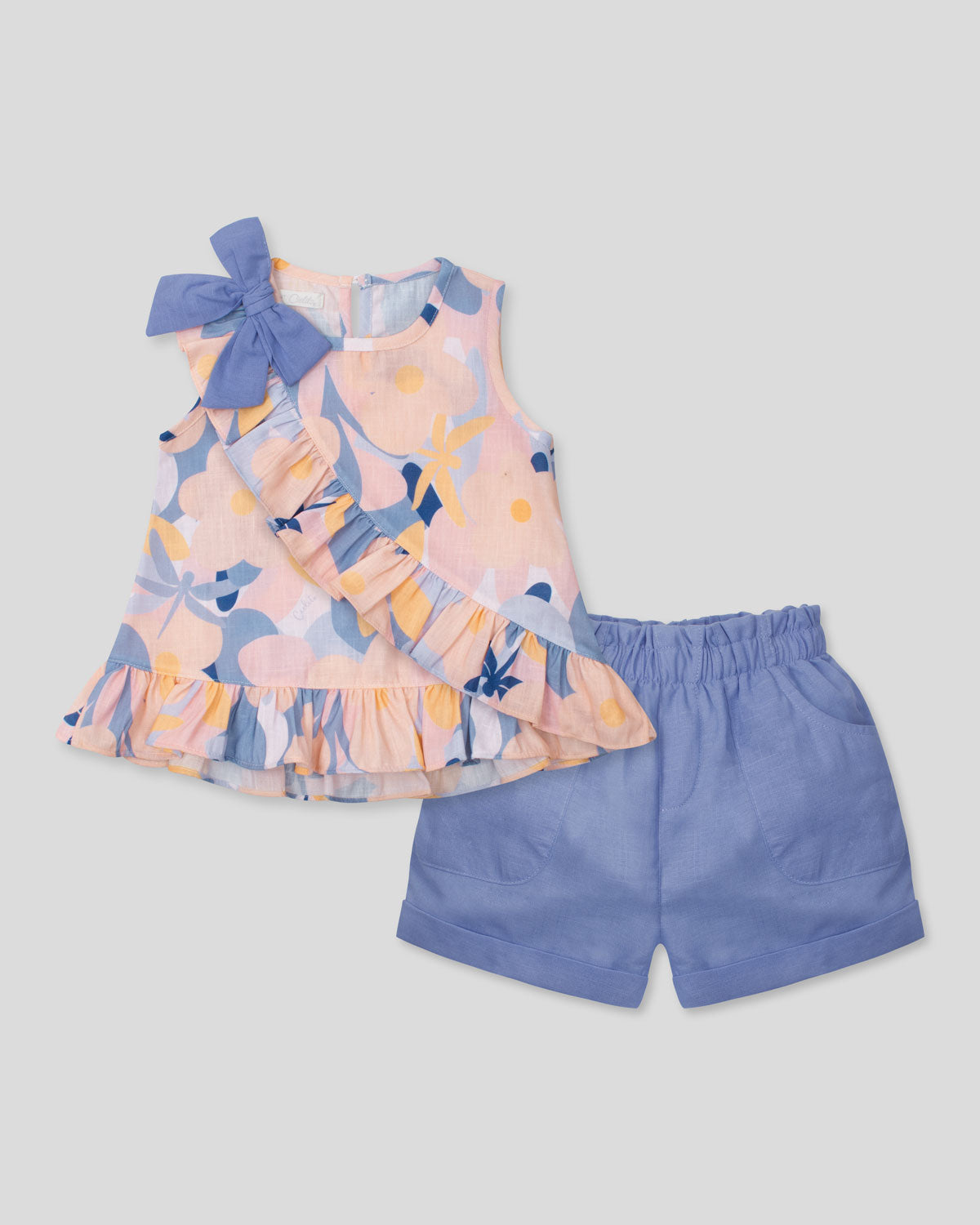 Conjunto blusa estampada con moño en hombro, boleto cruzado y short azul para niña