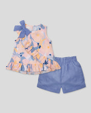 Conjunto blusa estampada con moño en hombro, boleto cruzado y short azul para niña
