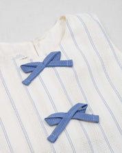 Conjunto blusa blanca con moñitos azules y falda short con prenses azul para niña