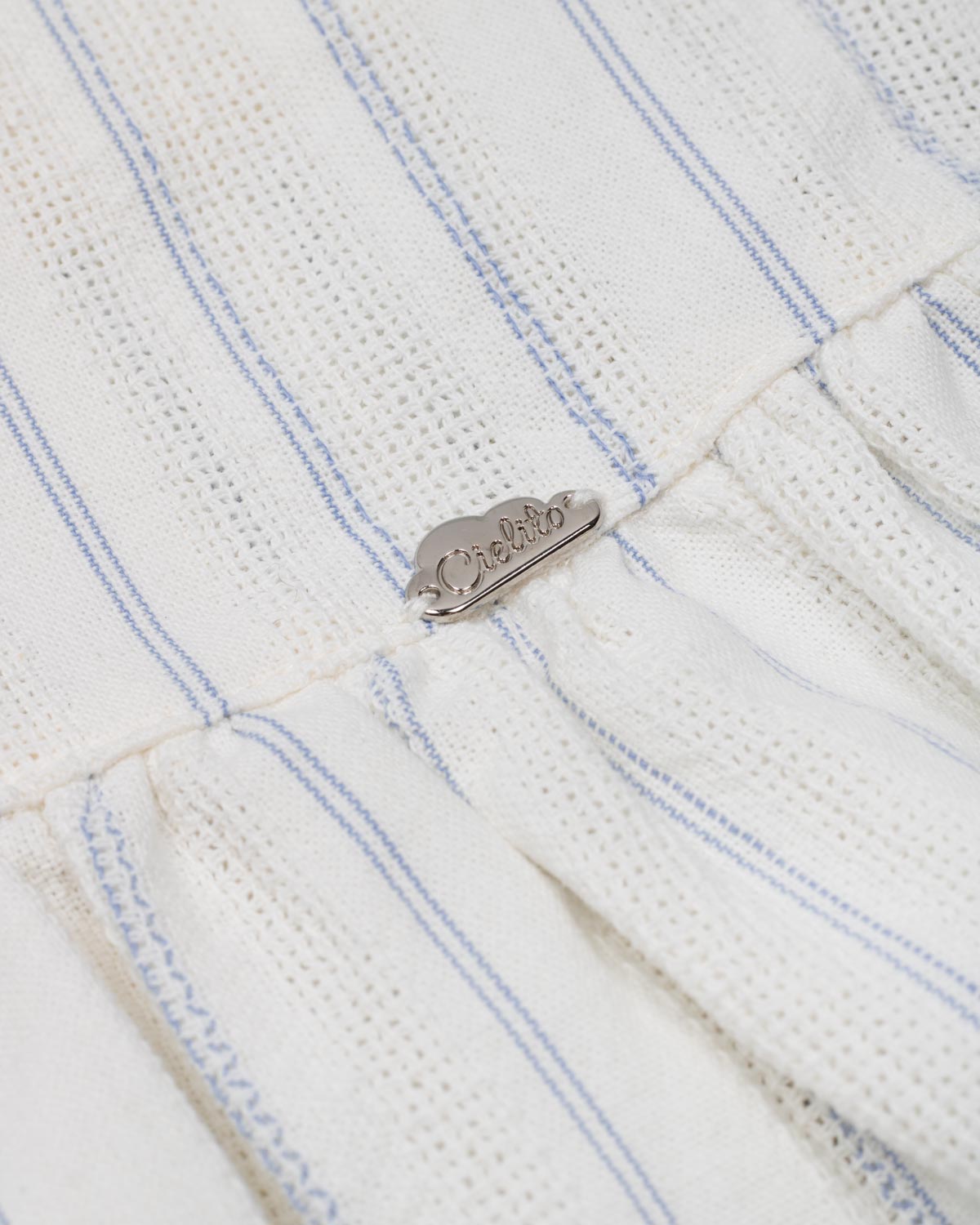 Conjunto blusa blanca con moñitos azules y falda short con prenses azul para niña