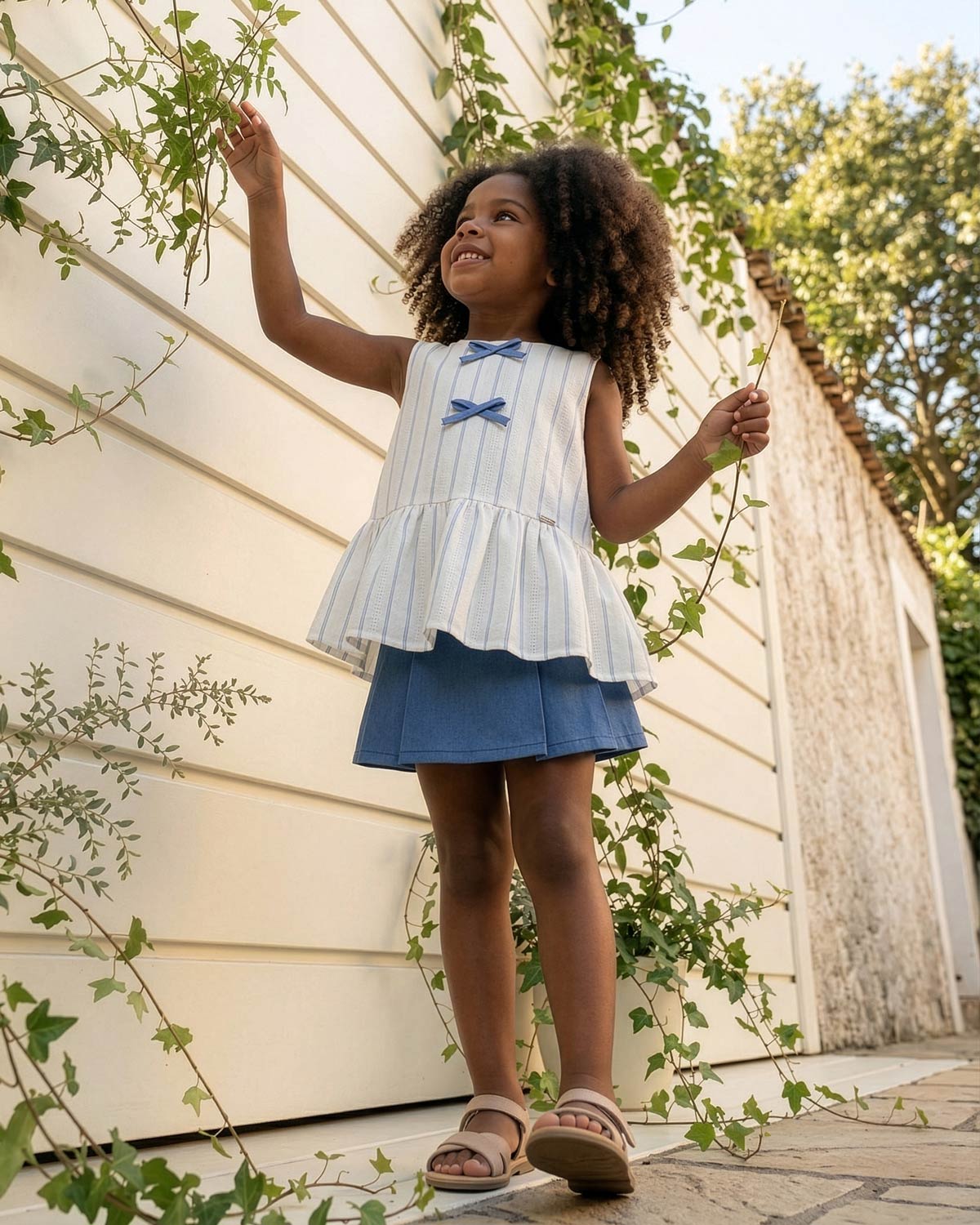 Conjunto blusa blanca con moñitos azules y falda short con prenses azul para niña