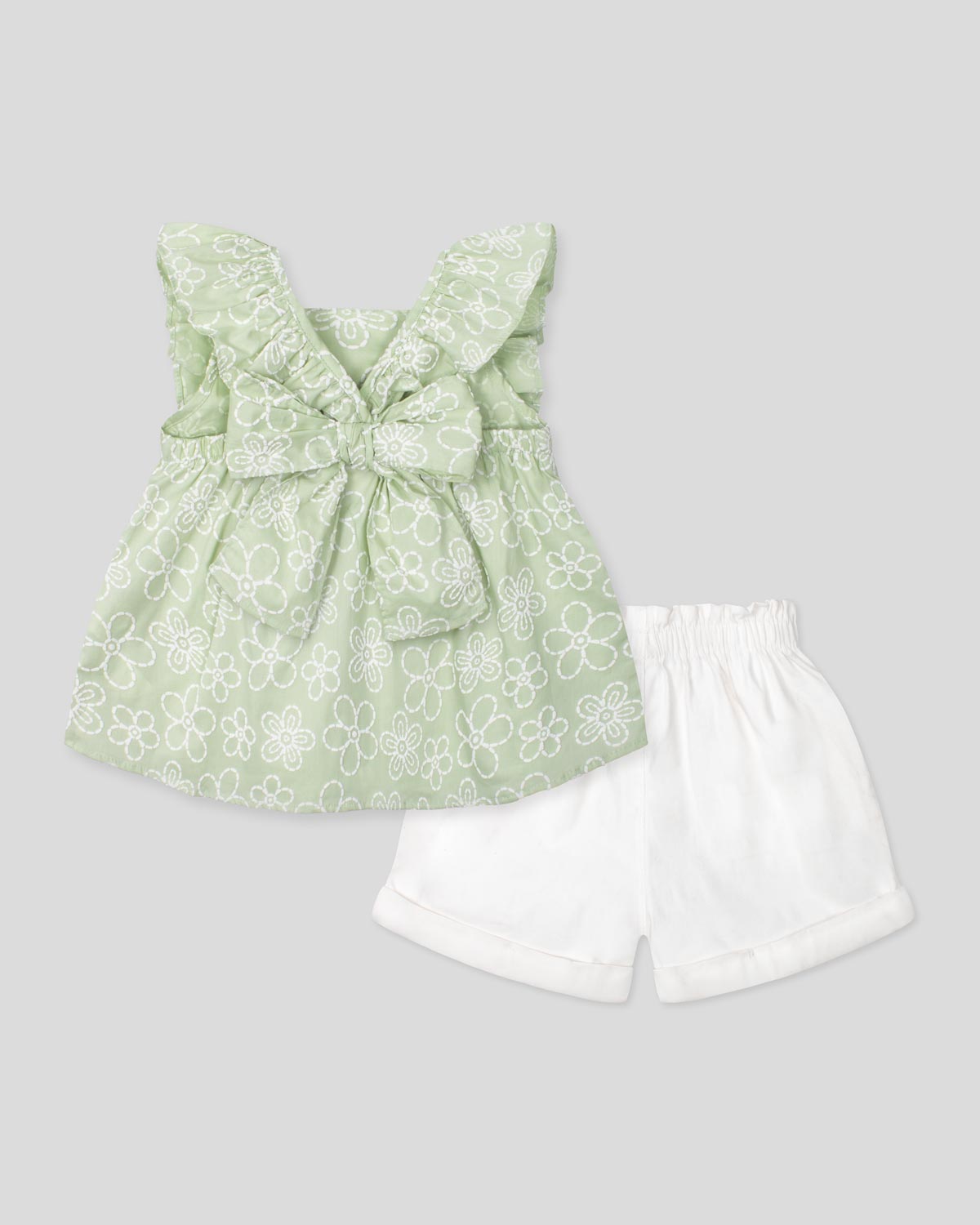 Conjunto blusa verde estampada con moño y short blanco para niña