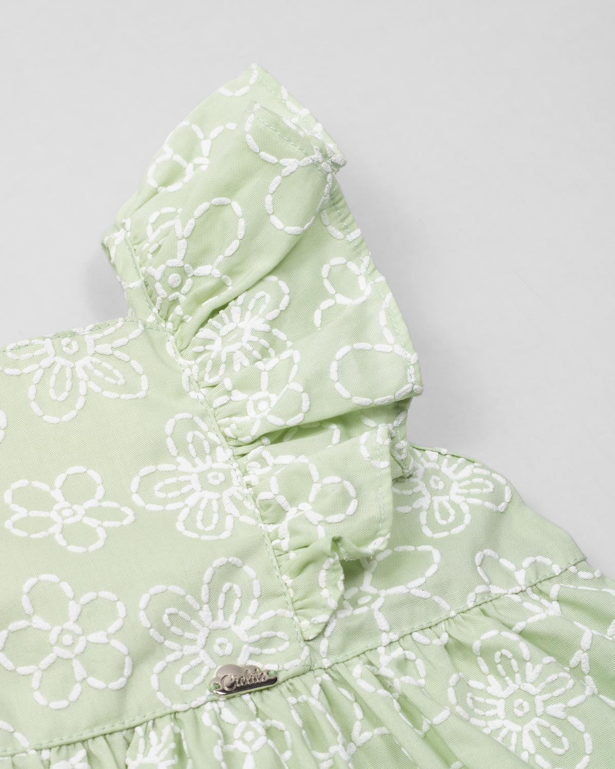 Conjunto blusa verde estampada con moño y short blanco para niña