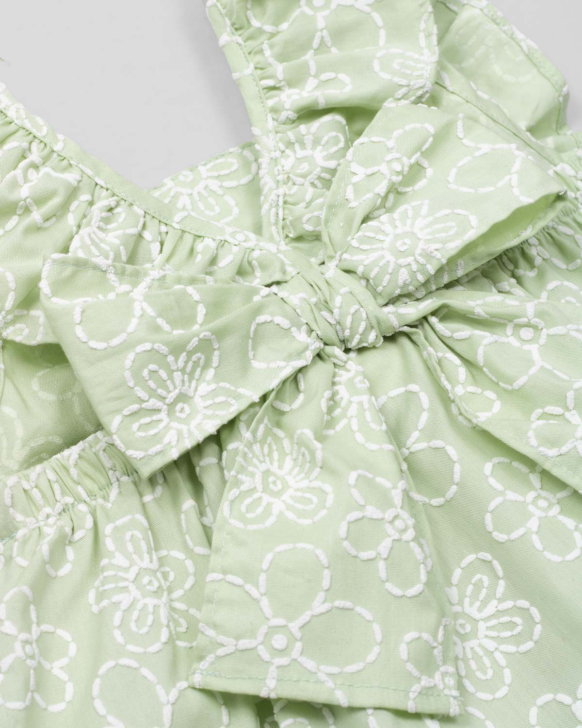 Conjunto blusa verde estampada con moño y short blanco para niña