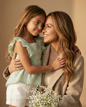 Conjunto blusa verde estampada con moño y short blanco para niña