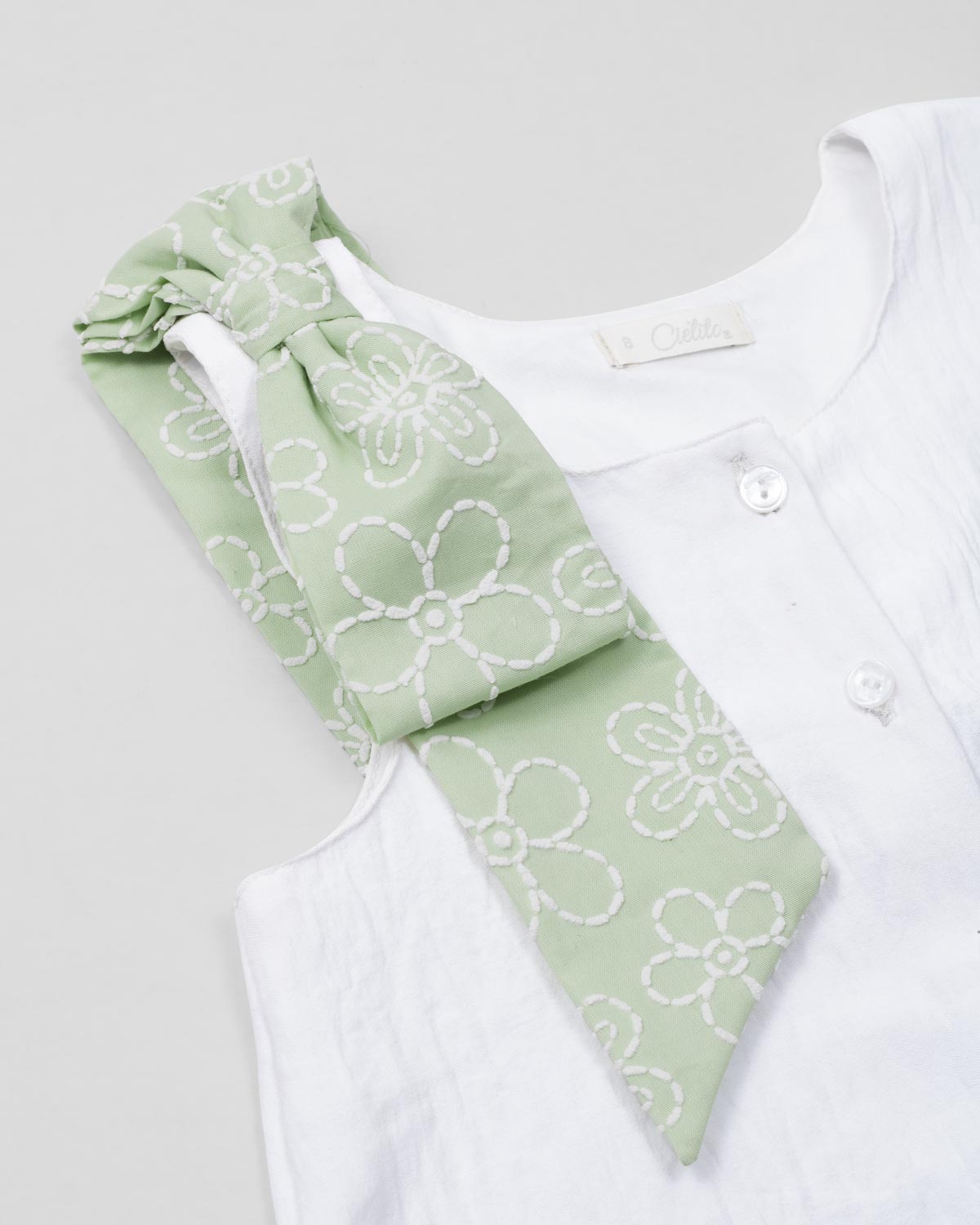 Conjunto blusa blanca con botones, moño y falda short verde estampado para niña