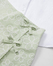 Conjunto blusa blanca con botones, moño y falda short verde estampado para niña