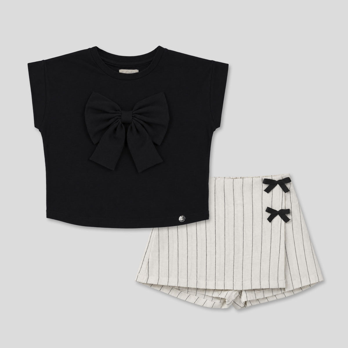 Conjunto blusa negra con moño y falda short en lino con rayas y moñitos para niña